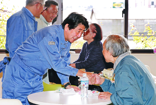 아베 신조(왼쪽) 일본 총리가 17일 제19호 태풍 ‘하기비스’로 피해를 입은 후쿠시마현 모토미야시 대피소를 방문해 한 이재민과 악수하며 위로 인사를 건네고 있다. 기록적인 폭우로 일본에서 이날 오후 2시 현재 77명이 숨지고 9명이 실종, 348명이 부상을 당했다.  AP뉴시스