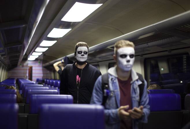 27일(현지시간) 얼굴에 페인팅을 한 사람들이 암스테르담으로 가는 기차에 오르고 있다. [AP=연합뉴스]