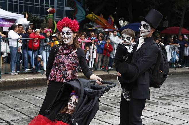 지난 26일(현지시간) 멕시코 수도 멕시코시티에서 한 가족이 죽음의 날 퍼레이드에 참석하고 있다. [AP=연합뉴스]