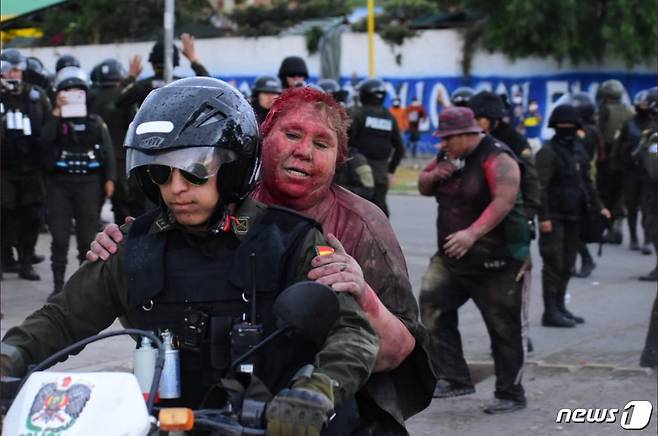 볼리비아의 한 여성 시장이 시위대에 집단 린치를 당한 뒤 경찰에 인계돼 안도의 한숨을 쉬고 있다. © 로이터=뉴스1 © News1 박형기 기자