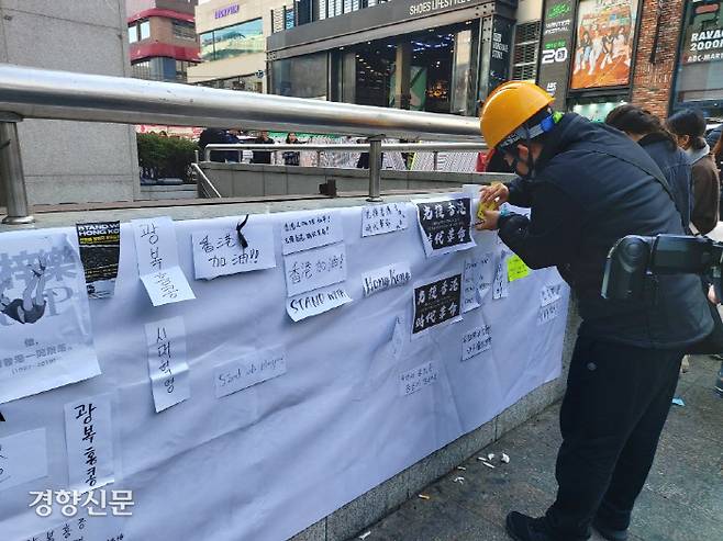 ‘홍콩 민주화 지지 모임’이 10일 오후 서울 마포구 홍대입구역 앞에 설치한 ‘레넌 월’에 한 참가자가 메모를 적고 있다. 이보라 기자