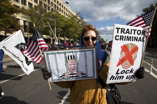 한 여성 시위자가 지난 8일 워싱턴에서 열린 반(反) 트럼프 집회에 참여해 도널드 트럼프 미국 대통령을 탄핵하고 감옥에 가둬야 한다는 내용의 그림들을 들고 있다. AP뉴시스
