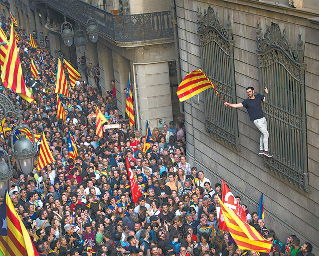 스페인 카탈루냐주의 독립주의자들이 2017년 10월 27일 주도 바르셀로나 주청사 앞에서 독립을 선포한 후 카탈루냐 기를 흔들며 행진하고 있다. 당시 중앙정부는 공권력을 투입해 즉각 자치권을 박탈했다. 이후 2년이 흘렀음에도 카탈루냐 독립을 둘러싼 찬반양론이 거세다. 바르셀로나=AP 뉴시스