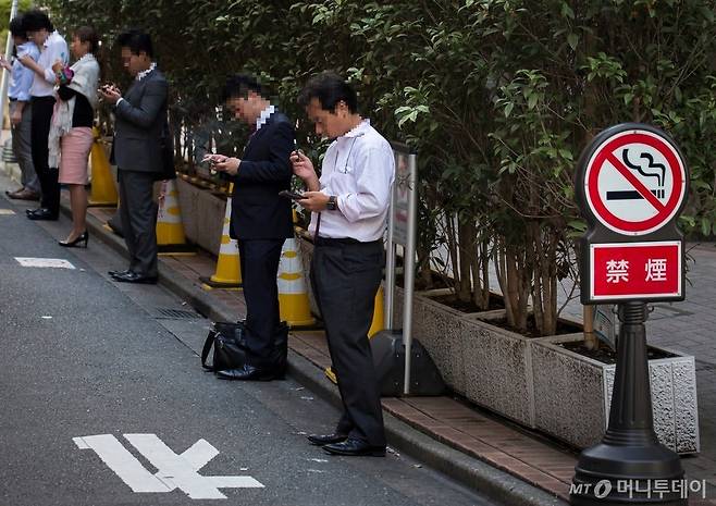 일본 도쿄 길거리 금연 구역에서 흡연중인 흡연자들. / 사진 = 뉴욕타임스