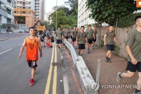 홍콩 거리에서 청소 작업을 벌이는 중국군에 포함된 대테러 특수부대원(왼쪽) [AFP통신=연합뉴스]