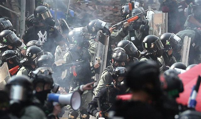 스펀지탄 쏘는 경찰  - 홍콩 이공대에 대한 진압 작전이 시작된 18일 교정에서 경찰과 시위대 간 공방전이 벌어진 가운데 경찰이 시위 참가 학생들을 향해 스펀지탄을 발포하고 있다.홍콩 뉴스1