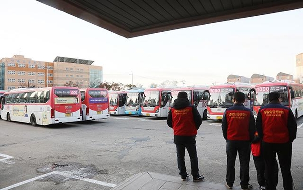 지난 19일 오전 경기도 고양시 대화동 명성운수 차고지에서 노조원들이 서 있는 버스들을 바라보고 있다. /연합뉴스