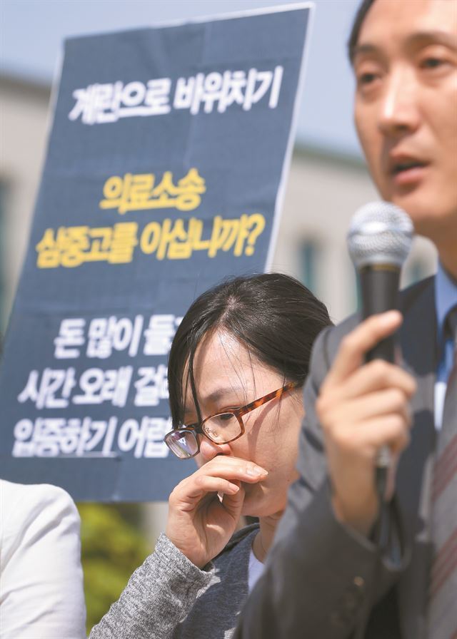 2014년 1월 서울의 한 대학병원 응급실을 찾았다가 7시간 만에 숨진 전예강(당시 9세)양의 어머니 최윤주(가운데)씨가 집회에 참석해 눈물을 흘리고 있다. 연합뉴스