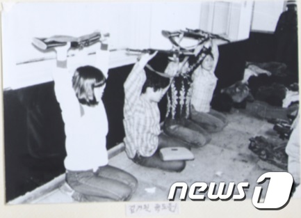 보안사가 공개한 사진 중 일부. 사진 속  여학생들이 총을 든 채 무릎을 꿇고 있다.(박지원 의원실 제공) /© 뉴스1