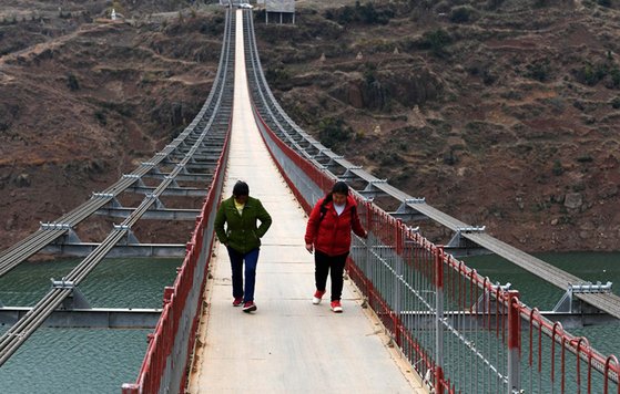 중국 구이저우와 위난성의 경계를 이루는 니우란강 위에 지난 12일 쇠줄 다리가 철거되고 새로운 현수교형 출렁다리가 건설됐다. [신하=연합뉴스]