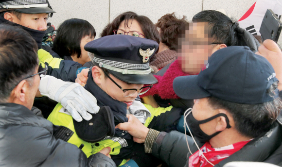 멱살잡힌 공권력 - 자유한국당이 16일 서울 여의도 국회에서 주최한 ‘공수처·선거법, 2대 악법 날치기 저지’ 규탄대회에 참가한 보수단체 회원들이 국회 본청 진입을 시도하다 막아서는 경찰과 몸싸움을 하고 있다.뉴스1