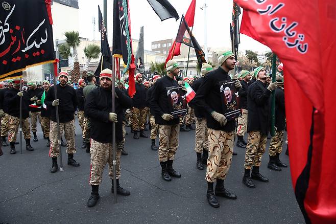 이란 군인들이 4일(현지시간) 수도 테헤란에 모여 거셈 솔레이마니의 죽음을 애도하면서 미국에 대한 가혹한 보복을 예고하는 깃발을 들고 있다.[로이터]