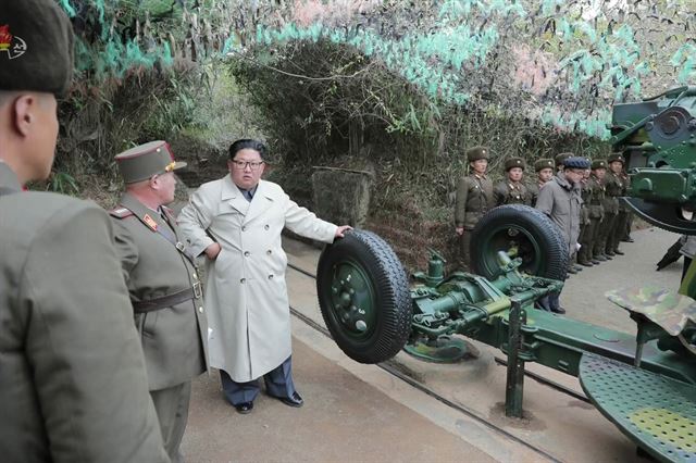 지난해 11월 25일 아이보리색 롱코트를 입은 김정은 북한 국무위원장이 서부전선의 황해남도 창린도 방어대를 시찰하면서 해안포로 추정되는 장비에 대한 설명을 듣고 있는 모습을 조선중앙TV가 보도했다. 조선중앙TV 연합뉴스