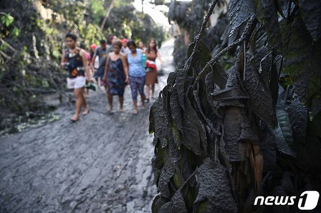 마닐라 남부 바탕가스주 타나우안 타운 주민들이 맨발로 마을을 빠져 나오고 있다. © AFP=뉴스1 © News1