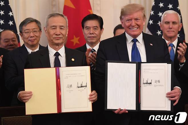 도널드 트럼프 미국 대통령은 활짝 미소를 짓고 있는데 비해 류허 중국 부총리는 이른바 '썩소'를 짓고 있다. © AFP=뉴스1 © News1 박형기 기자