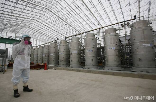 일본 후쿠시마현 원전 오염수 처리시설에서 한 직원이 방사성 물질 보호복을 입고 서있는 모습. 사진=AP/뉴시스