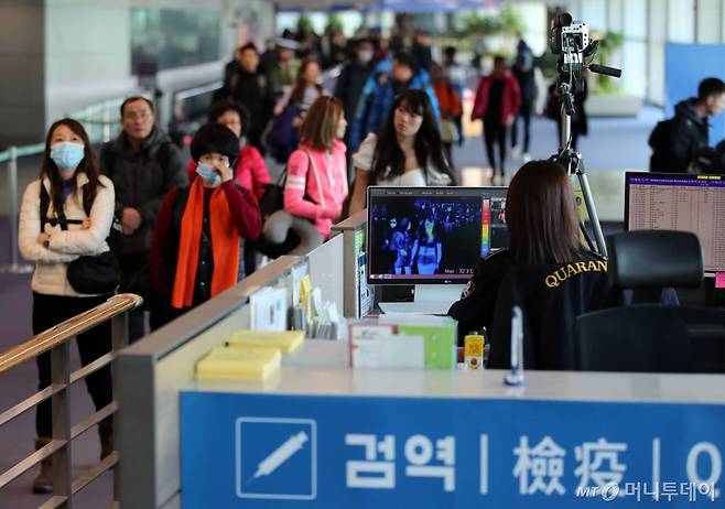 인천국제공항에서 질병관리본부 국립검역소 직원들이 중국발 항공기를 통해 입국하는 승객들의 체온을 측정하고 있다. /사진=이기범 기자.