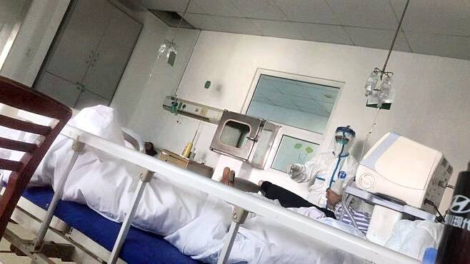 지난 13일 중국 우한시 진인탄 병원 중환자실. 의료진이 방호복을 입고 신종 폐렴 환자들을 진료하고 있다. [중앙포토]