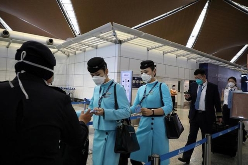 27일 말레이시아 쿠알라룸푸르의 공항에서 승무원들이 마스크를 쓰고 이동하고 있다. /로이터 연합뉴스
