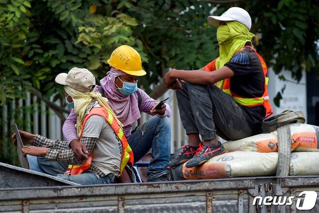 지난달 31일 캄보디아 수도 프놈펜에서 신종 코로나바이러스 감염을 막기 위해 마스크를 착용하고 있는 건설 노동자들. © AFP=뉴스1