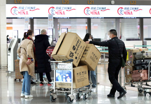 3일 오후 인천국제공항 제1여객터미널 앞에서 중국인 여행객들이 마스크 박스가 가득 실린 카트를 밀며 탑승 수속대로 향하고 있다. [연합뉴스]