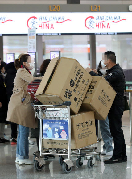 - 3일 오후 인천국제공항 1터미널에서 중국인 여행객들이 마스크 박스가 실린 카트를 밀고 탑승수속대로 향하고 있다.  2020.2.3 연합뉴스