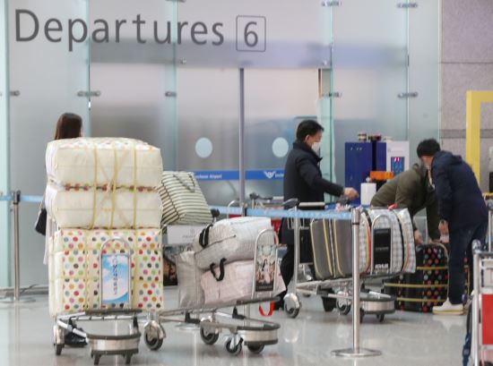 4일 오후 인천국제공항에서 공항 이용객들이 마스크가 든 수레를 운반하고 있다. 연합뉴스