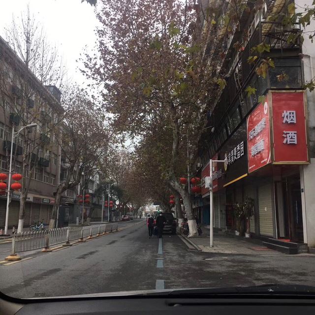 중국 후베이성 우한의 어느 주택가 이면도로. 모든 상점의 문이 닫혀 있다. 일부 행인을 제외하고 거리는 휑하다. 차 안에서 이동 중에 찍었다. 독자 제공