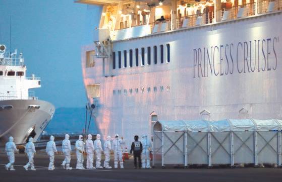 방호복을 입은 일본 방역당국 관계자들이 지난 7일 일본 요코하마항에 정박 중인 크루즈 다이아몬드 프린세스에 오르고 있다. [로이터=연합뉴스]