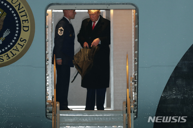 [메릴랜드=AP/뉴시스]11일(현지시간) 도널드 트럼프(오른쪽) 미국 대통령이 미국 메릴랜드주 앤드루스 공군 기지에 착륙한 전용기 에어포스원에서 우산을 펴며 내릴 준비를 하는 모습. 2020.02.12.