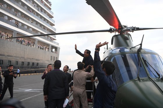 훈센 총리가 헬기에서 내리면서 웨스테르담호 승객들을 향해 손을 흔들고 있다. [AFP=연합뉴스]