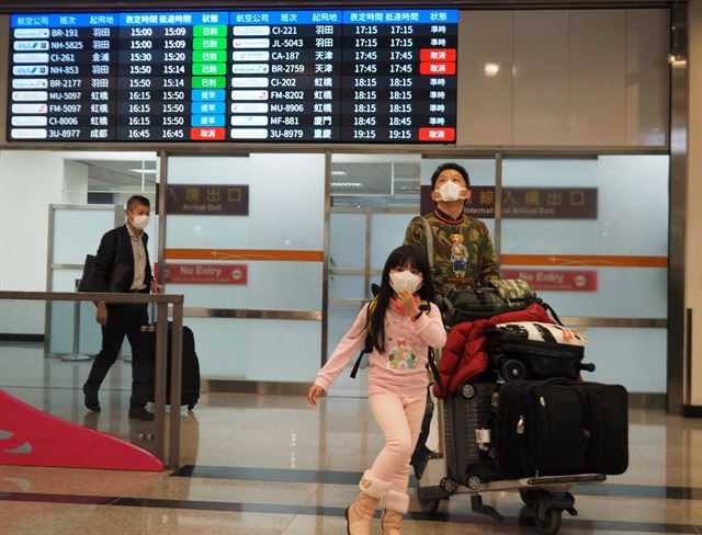 16일 대만 타이페이 송산공항에 도착한 승객들이 마스크를 쓴 채 입국장을 빠져 나오고 있다. 타이페이=EPA 연합뉴스