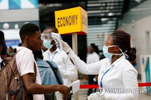 1월30일(현지시간) 아프리카 가나의 아크라 국제공항에서 보건당국 직원들이 코로나19 검역 차원에서 여행객들을 상대로 발열 검사를 진행하고 있다. (로이터=연합뉴스)