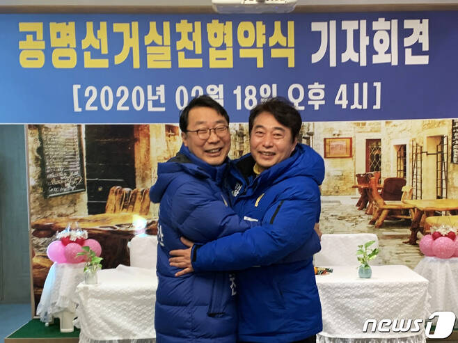 윤영찬·조신(오른쪽) 후보가 공명선거 실천 협약식 기자회견에서 포옹을 하고 있다.(민주당 지역위원회 제공) © News1