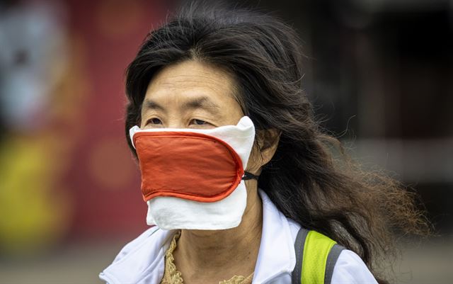 18일 중국 광둥성 광저우에서 한 여성이 속을 덧대 개량한 독특한 모양의 마스크를 착용하고 거리를 걷고 있다. 광저우=EPA 연합뉴스