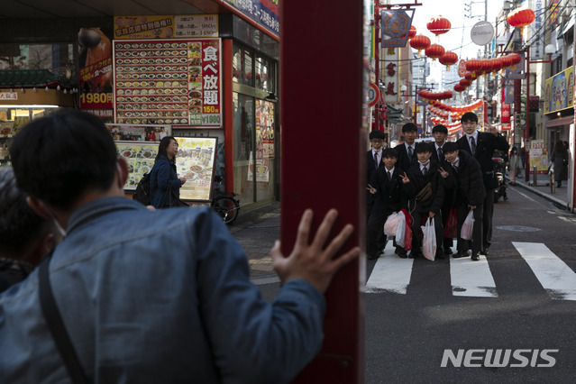[요코하마=AP/뉴시스]13일 일본 도쿄 인근 요코하마의 차이나타운을 찾은 학생들이 단체사진을 찍고 있다.  2020.02.14.