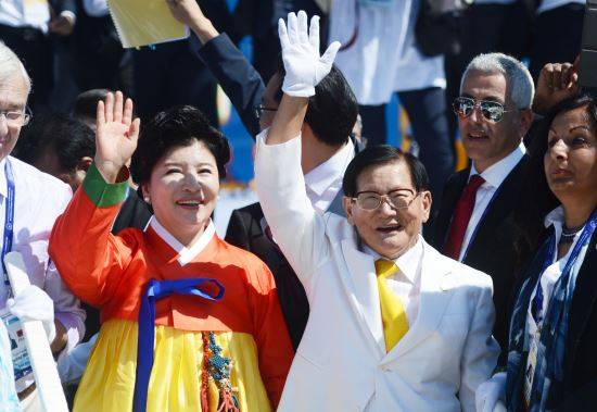 이만희(오른쪽) 신천지 교주와 김남희(왼쪽)씨가 2015년 9월 18일 서울 송파구 방이동 올림픽공원 평화의 문에서 열린 '종교대통합 만국회의 1주년 기념식' 손을 흔드는 모습. 뉴시스