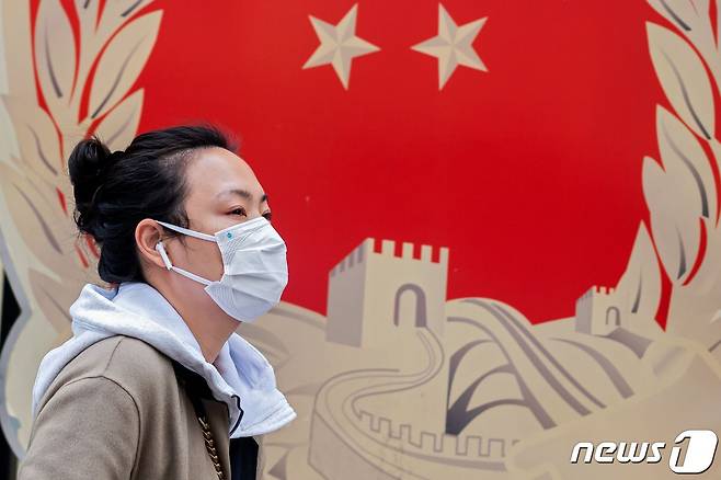 2일(현지시간) 중국 베이징에서 마스크를 쓴 여성이 거리를 걸어가고 있다. @AFP=뉴스1