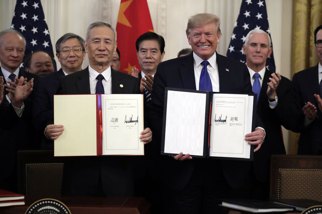 도널드 트럼프 미국 대통령(오른쪽)과 류허 중국 부총리가 2020년 1월15일(현지시각) 미국 워싱턴 백악관에서 미-중 1단계 무역합의안에 서명한 뒤 들어 보이고 있다. 연합뉴스