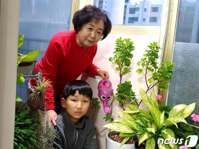 박영자 할머니(74)가 대구 중구 자택에서 손주와 함께 화분에 물을 주고 있다. (박영자씨 제공)© 뉴스1