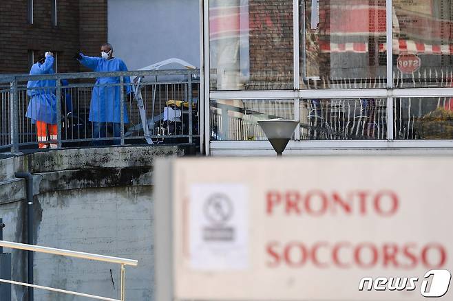 이탈리아 전역에 이동제한령이 내려진 다음 날인 11일(현지시간) 밀라노 남동부 코도뇨에 있는 한 병원 응급실 입구에 의료진들이 서 있다. © AFP=뉴스1