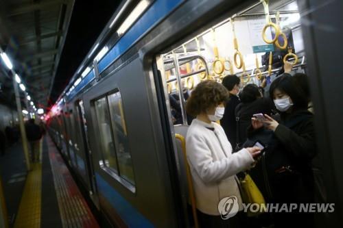 (교토 로이터=연합뉴스) 13일 일본 교토(京都)시에서 마스크를 쓴 사람들이 지하철에서 휴대전화를 들여다보고 있다. 2020.3.16