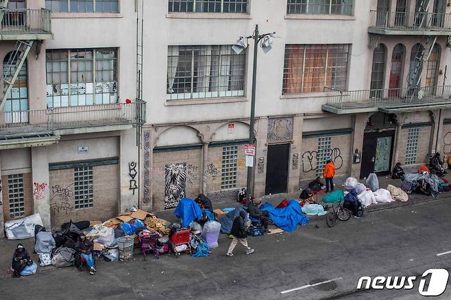 19일(현지시간) 코로나19 확산 속 캘리포니아주 로스앤젤레스 중심가의 건물 앞에 노숙자들이 모여 있다. © AFP=뉴스1 © News1 우동명 기자