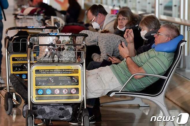 20일 스페인 마드리드에 있는 바라하스 아돌포 수아레스 공항에 승객들이 앉아 있다. © AFP=뉴스1