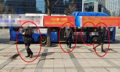 지난 21일 서울 종로구 광화문 사거리 인근 버스 정류장 가로수에는 사람 키 높이의 현수막이 걸려 있다. 버스에서 내린 시민들은 현수막 주변이나 밑으로 지나다니며 불편을 겪고 있다.