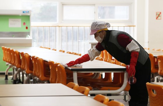 초·중·고교가 4월 9일부터 순차적으로 온라인 개학을 하게 되면서 각 학교 급식실은 운영이 무기한 중단될 전망이다. 3월 18일 서울의 한 초등학교 급식실에서 관계자가 식탁과 의자를 닦고 있다. [연합뉴스]