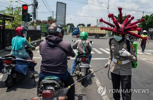 코로나 모자 쓰고 방역 활동하는 인도네시아 경찰 [AFP=연합뉴스]