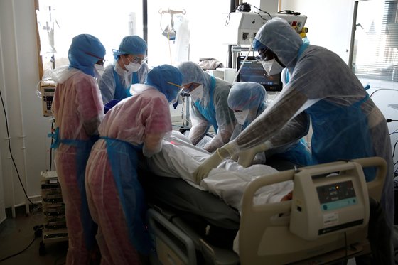 6일 프랑스 파리에 있는 한 병원에서 신종 코로나로 고통스러워하는 환자를 방호복을 입은 의료진이 치료하고 있다. [로이터=연합뉴스]