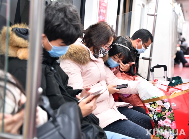 [시안=신화/뉴시스]27일(현지시간) 중국 산시성 시안의 한 지하철 탑승객들이 마스크를 착용한 채 이동하고 있다. 구를 소독하고 있다. 시안시 관계자는 신종 코로나바이러스의 확산을 막기 위해 지하철역, 관광지, 공공 지역 등의 소독 및 검역을 강화했다고 밝혔다. 2020.01.28.