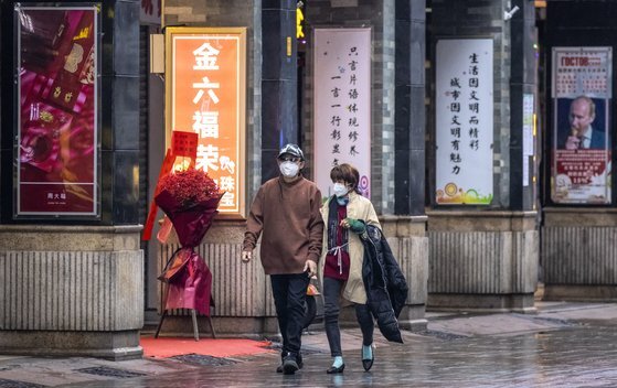 발렌타인데이인 지난 2월 14일 중국 광저우 시내를 마스크를 쓴 시민이 걷고 있다. 당시 코로나19로 대부분의 식당이 문을 닫았다. EPA=연합뉴스